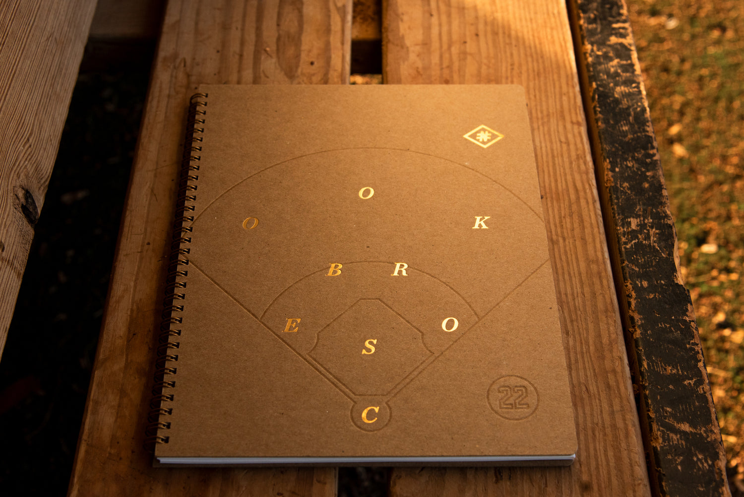 Number 22 scorebook on dugout bench showing metallic foil printing with dramatic reflection