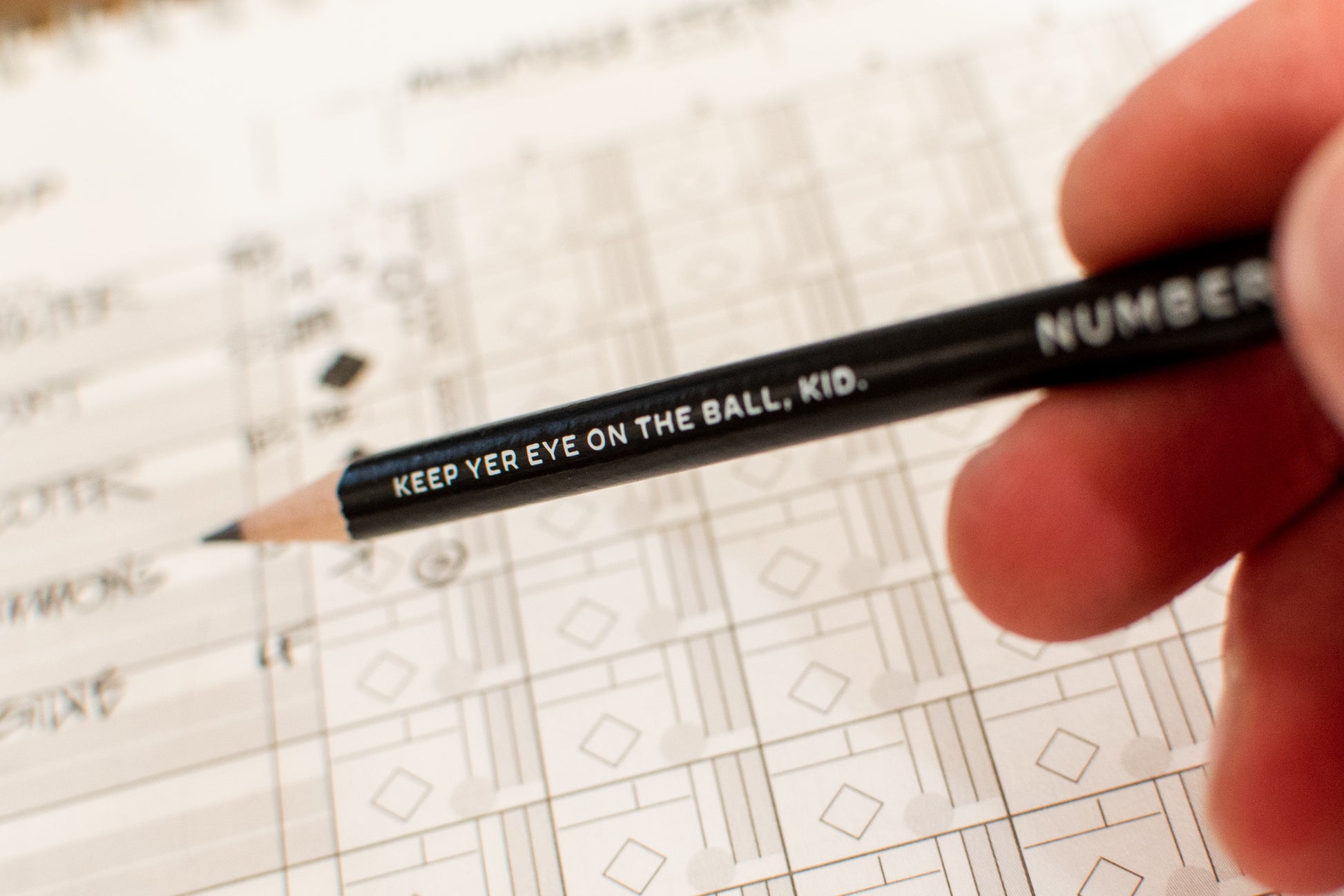 A sharpened Numbers Game pencil being used to fill in a scoresheet